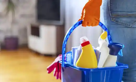 Cleaner carrying a bucket of cleaning supplies